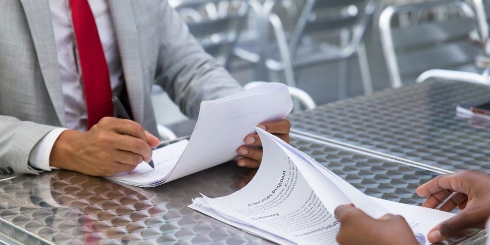 Business partners checking and signing document